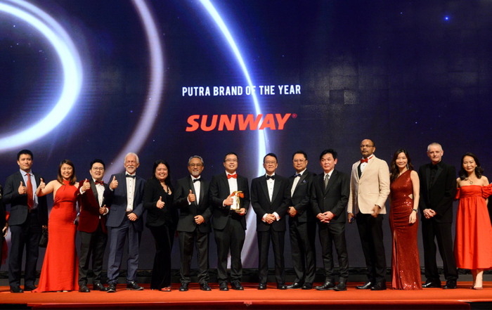 A full landscape group photo of Sunway Group founder and chairman flanked by the group’s diverse team comprising key spokespersons, upon winning the Putra Brand of the Year award on stage.