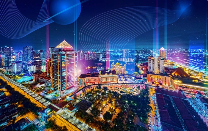 An aerial shot of Sunway City Kuala Lumpur at dusk with breathtaking cityscape surrounded by shimmering curtains of neon-like light.