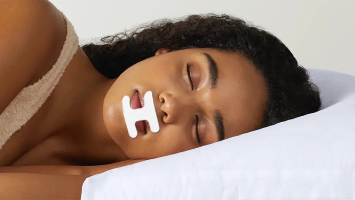 A close-up shot of a lady taping her mouth as she falls asleep