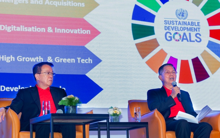 Mid shot of Sunway Group founder and chairman Tan Sri Sir Dr. Jeffrey Cheah and Sunway Group president Tan Sri Dato' Chew Chee Kin speaking at the Sunway Leaders Conference 2023, with the UN-SDGs in the background