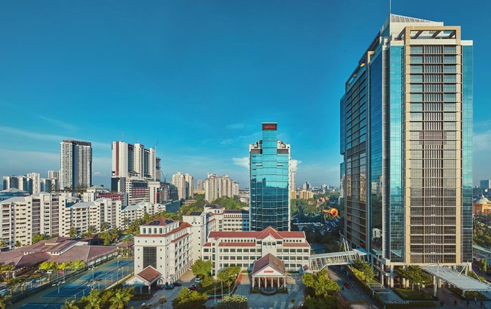 A centralised drone shot of Menara Sunway, Sunway Pinnacle and buildings of Sunway City Kuala Lumpur amidst a blue morning sky