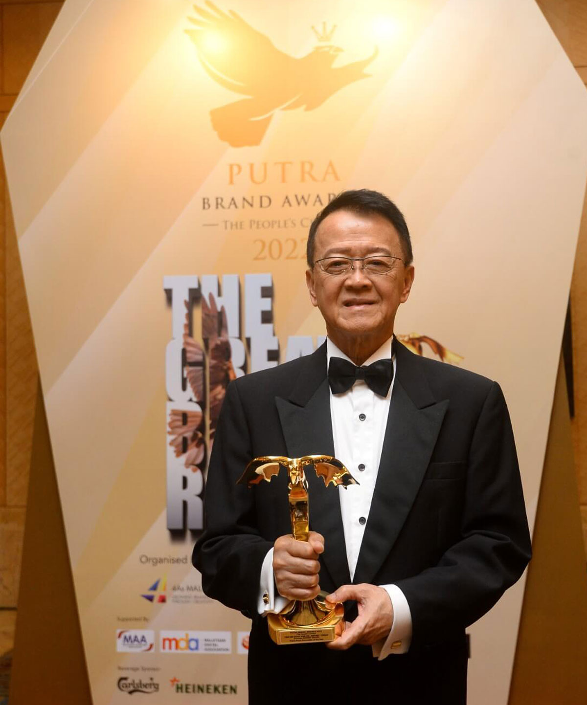 Tan Sri Sir Dr. Jeffrey Cheah holding his Putra Personality of the Year Award at the Putra Brand Awards 2022.