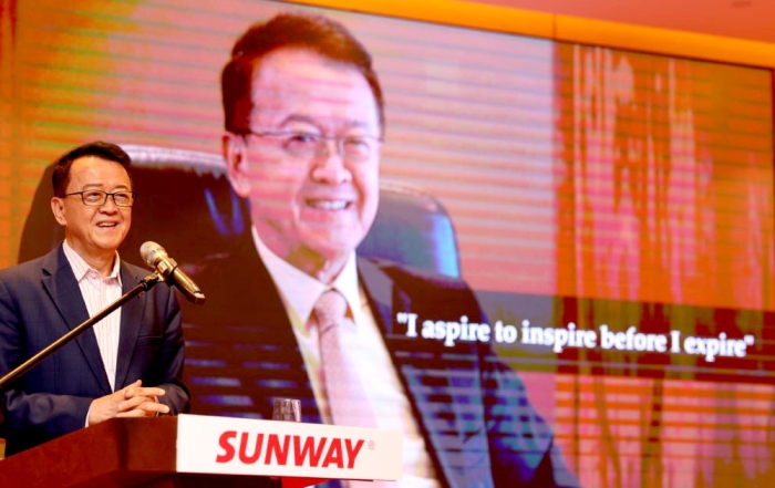 Tan Sri Sir Dr. Jeffrey Cheah giving a speech with the background photo being his iconic quote “I aspire to inspire before I expire.”