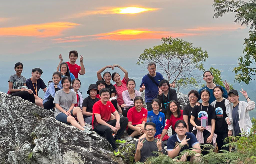 Group Internal Audit Department taking a group phpto with the sunset during their hike.