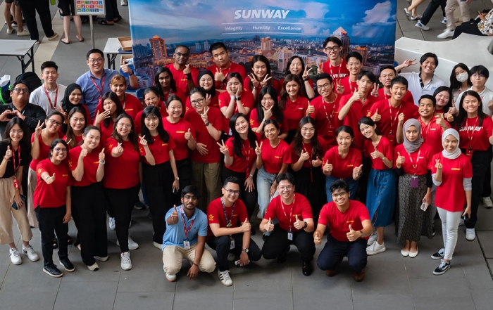 A high angled shot of Sunway staff with the Sunway backdrop at Sunway University