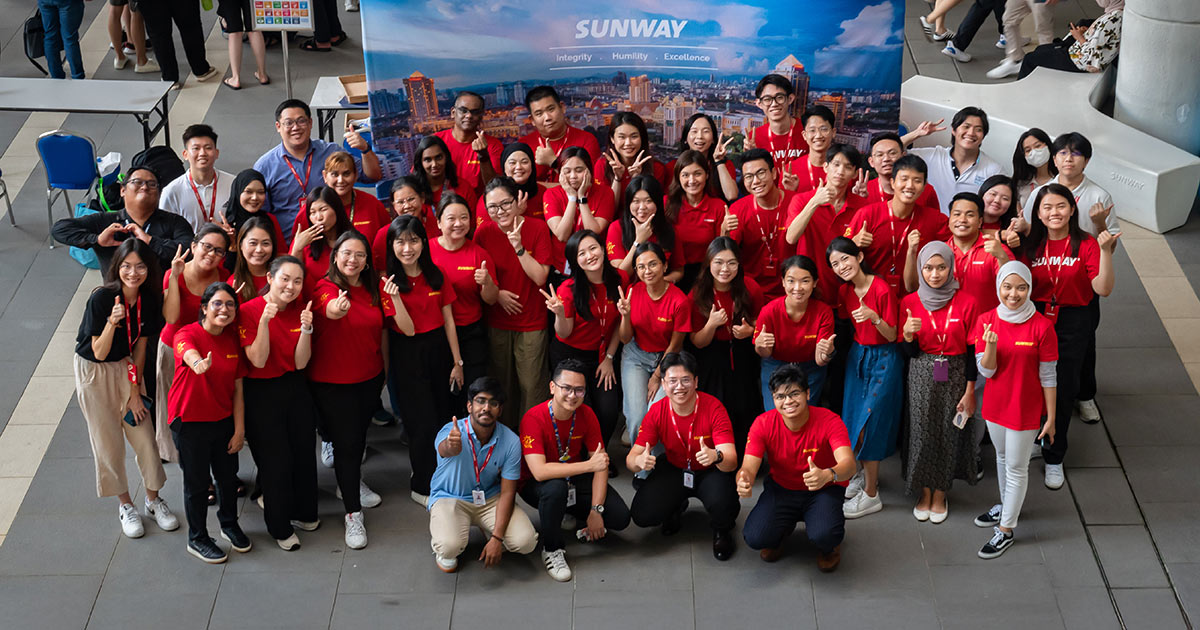 A high angled shot of Sunway staff with the Sunway backdrop at Sunway University