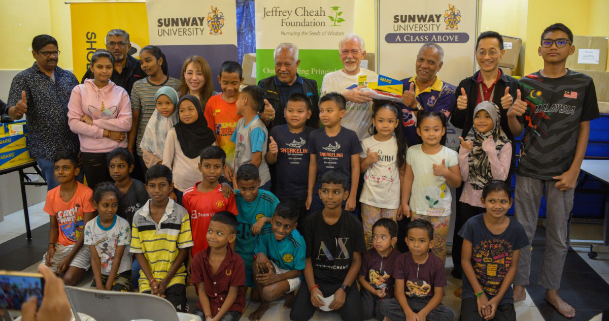 Group shot of Sunway University’s leadership team alongside community leaders and children of Desa Mentari.