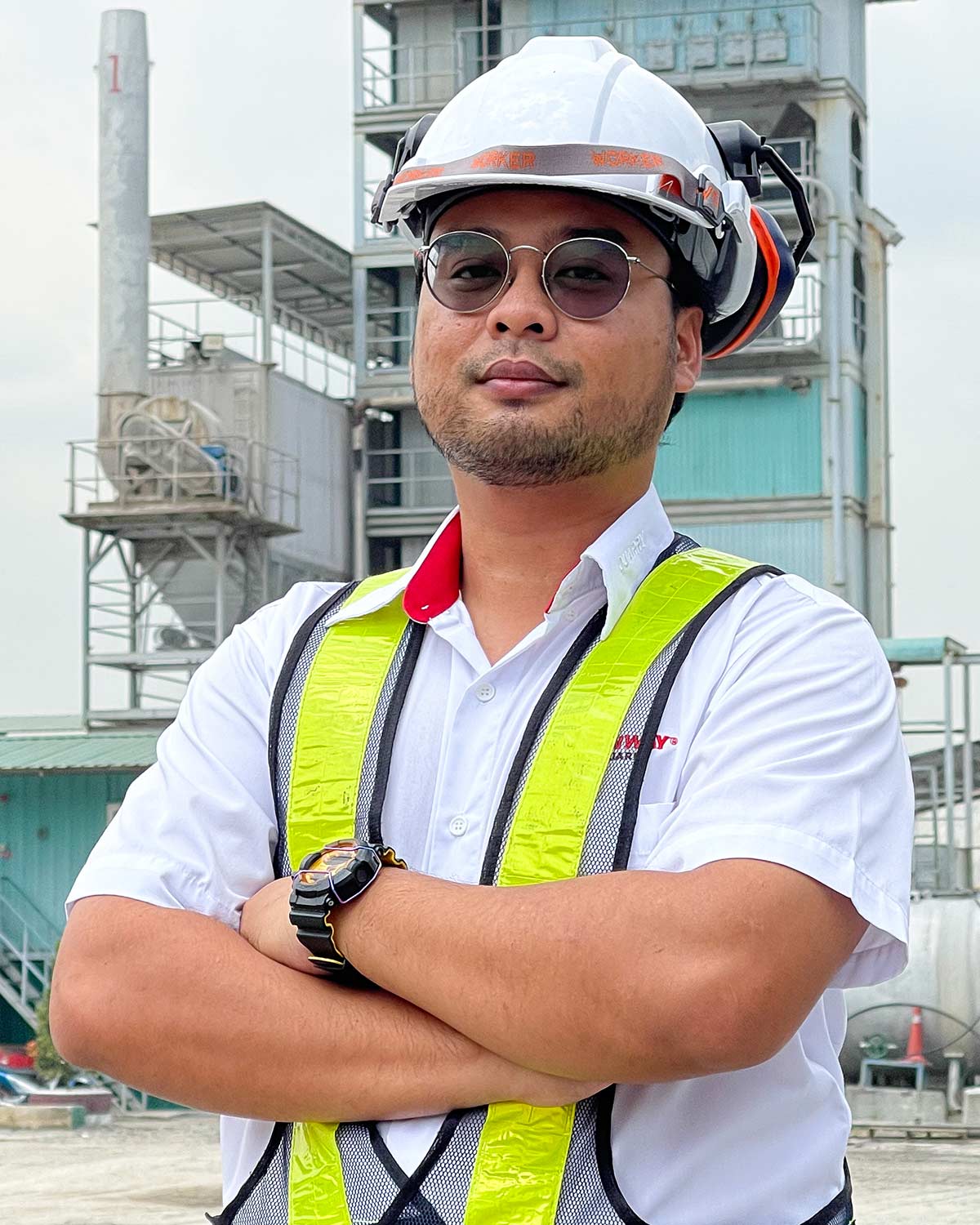 A mid-shot of Nur Faridzamil bin Nordin, Senior executive, QA/QC, Sunway Quarry, with Sunway Quarry equipment in the background